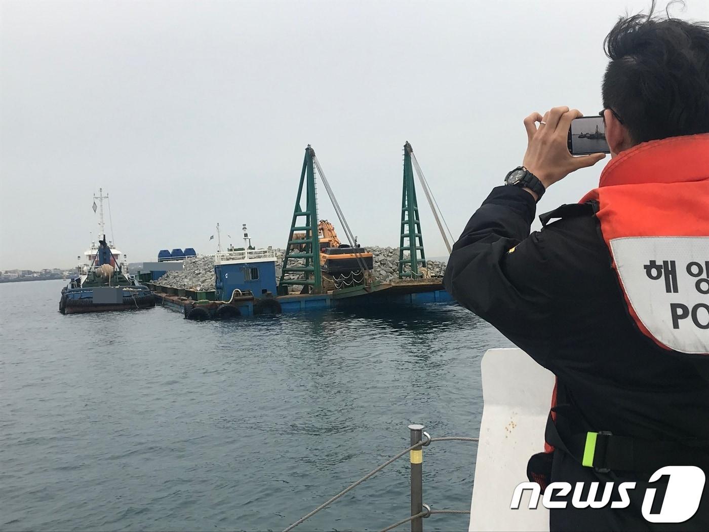 본문 이미지 - 해경이 25일 오후 7시10분 제주항 인근에서 만재흘수선을 초과한 선적을 적발하고 있다(제주해경 제공)ⓒ 뉴스1