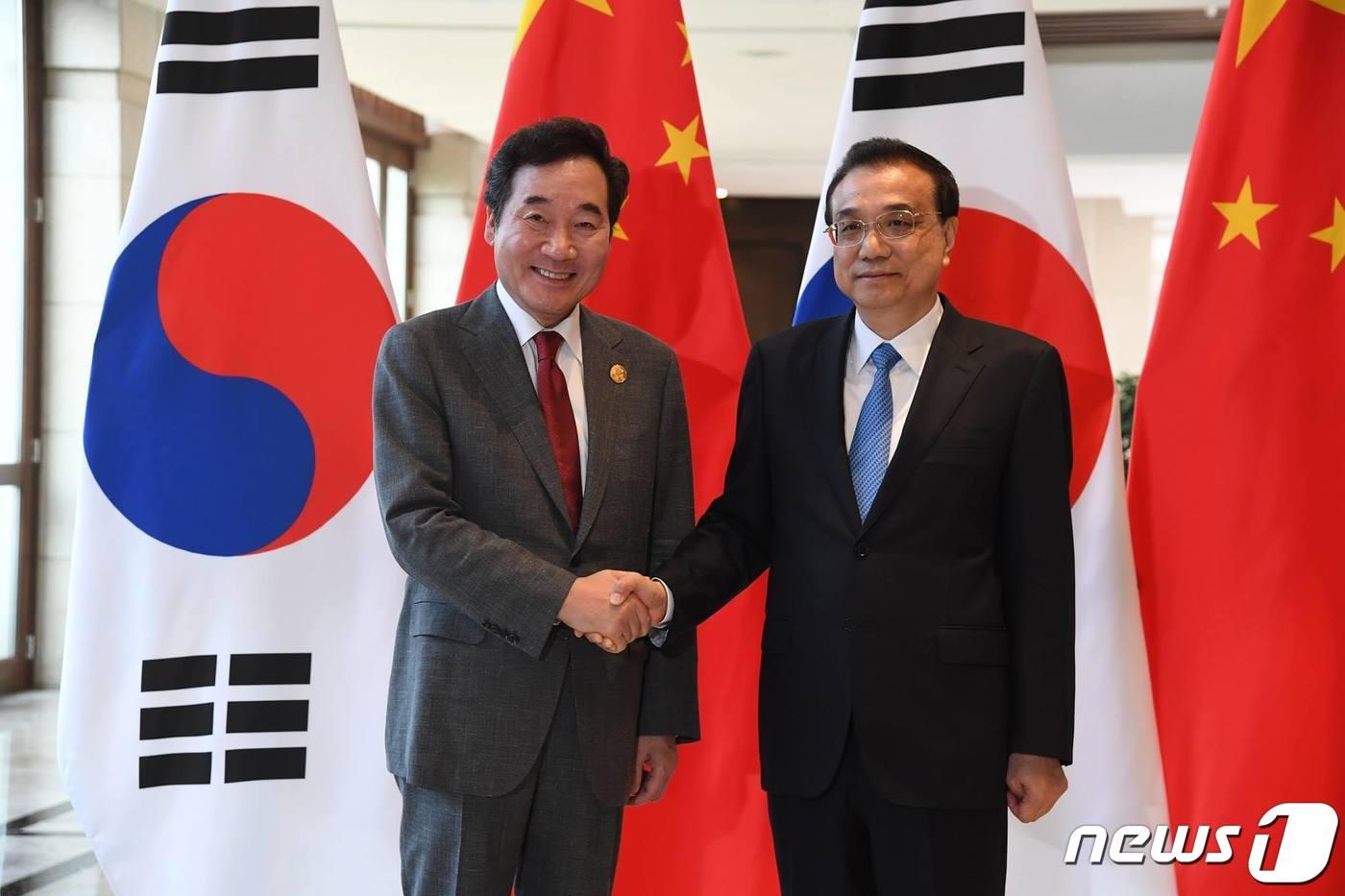 본문 이미지 - 이낙연 총리가 2019년 보아오포럼 연차총회 전날인 27일 중국 하이난에서 리커창 중국 총리를 만나 악수하고 있다. 