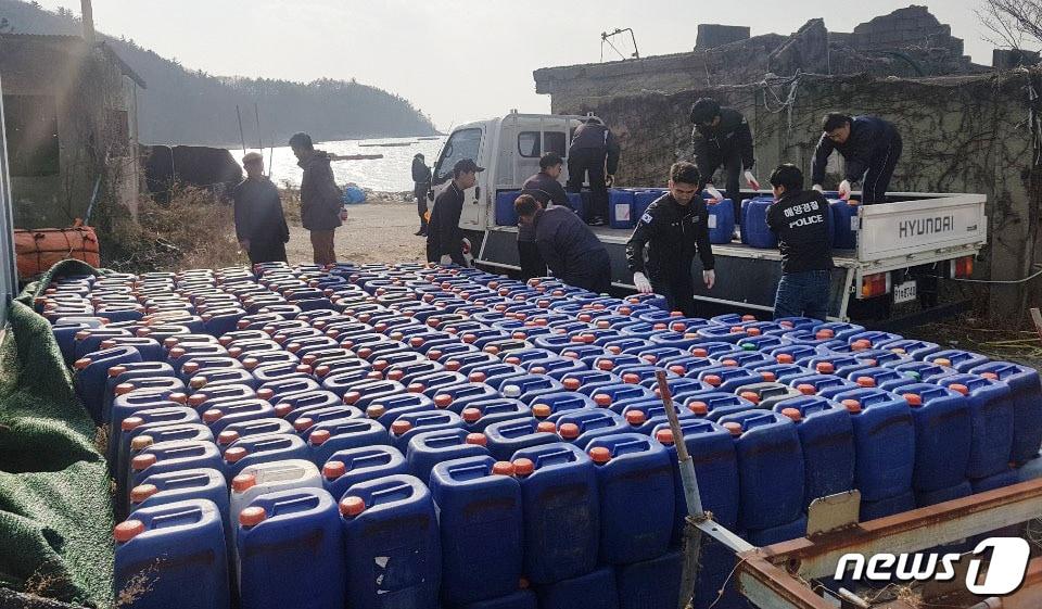 본문 이미지 - 해경대원들이 불법으로 보관한 무기산을 압수하고 있다.(해양경찰청 제공)ⓒ 뉴스1