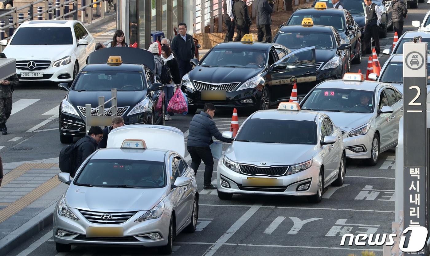 본문 이미지 - 택시·카풀 업계 상생을 위한 사회적 대타협기구가 7일 최종 담판에서 '출·퇴근 시간 카풀 허용'과 '택시 월급제'를 골자로 한 합의안을 도출했다. 이날 서울 중구 서울역 앞에서 택시들이 오가고 있다. 2019.3.7/뉴스1 ⓒ News1 이승배 기자