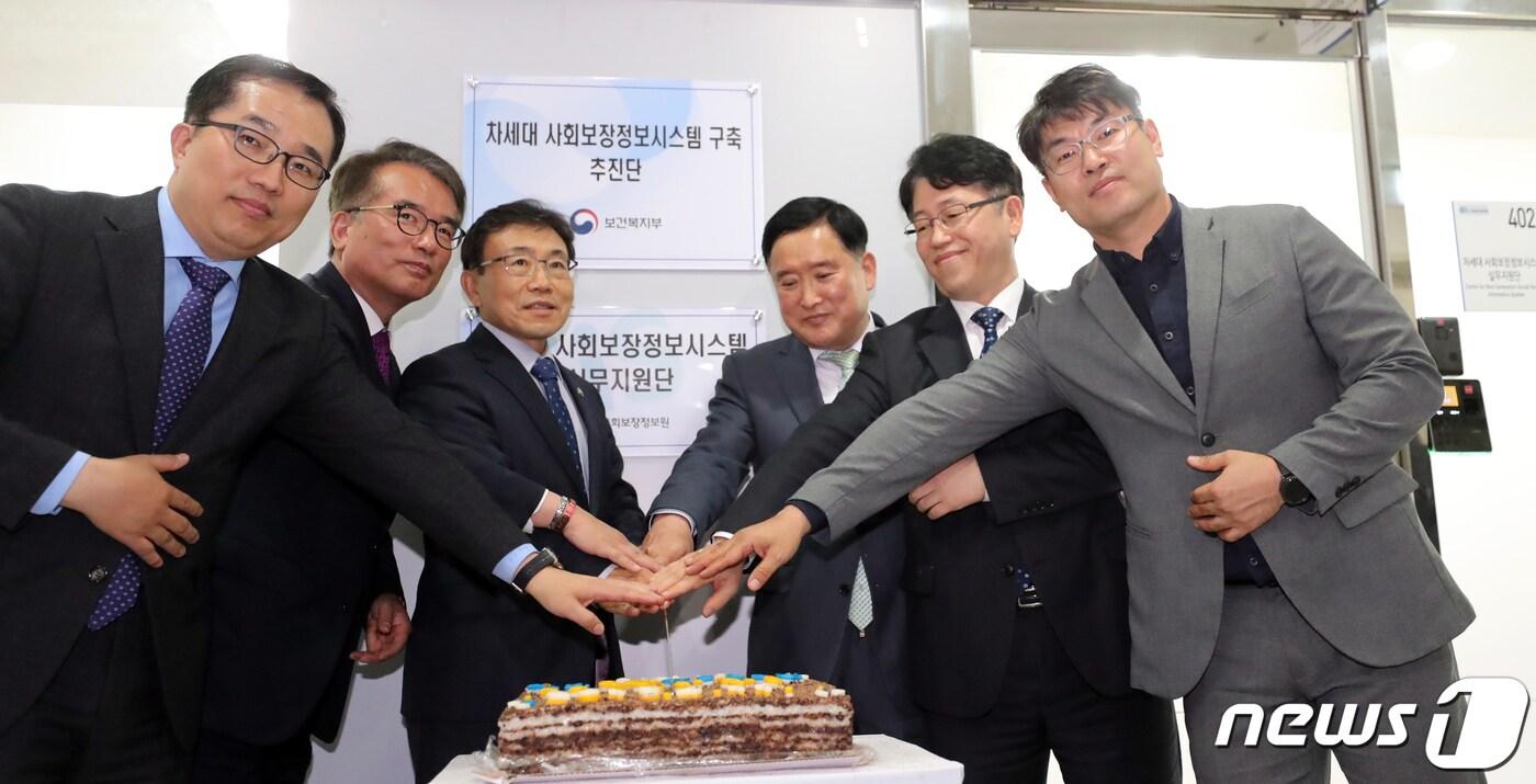본문 이미지 - 4일 세종시 나성동에서 열린 보건복지부의 차세대 사회보장정보시스템 구축 추진단 및 사회보장정보원의 실무지원단 개소식에서 권덕철 보건복지부 차관 등 참석자들이 현판식을 마친 뒤 축하 떡 커팅식을 갖고 있다. 2019.4.11/뉴스1 ⓒ News1 장수영 기자