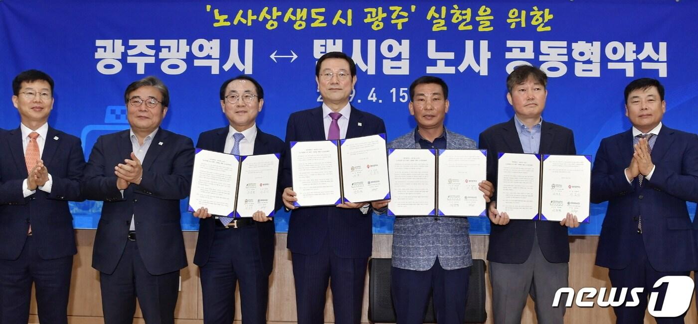 본문 이미지 - 이용섭 광주시장이 15일 오전 시청 2층 무등홀에서 열린 '노사상생도시 광주만들기' 실현을 위한 광주시-택시업 노사간 공동협약식에 참석해 협약서에 서명을 한 뒤 기념촬영을 하고 있다. 왼쪽부터 박병규 광주시사회연대일자리특보, 이병훈 광주시 문화경제부시장, 정동광 광주택시운송사업조합 이사장, 이용섭 광주시장, 최진영 광주지역택시노동조합 의장, 안윤택 전국민주택시노동조합 광주본부장.(광주시 제공)2019.4.15/뉴스1 ⓒ News1