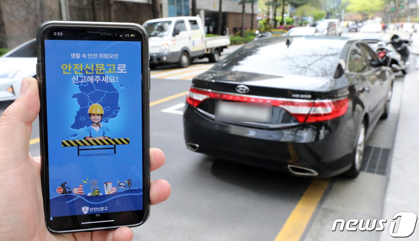 행정안전부는 '4대 절대 불법 주·정차 관행'을 근절하기 위한 범국민운동을 추진하고 주민신고제를 본격적으로 시행, 안전신문고 앱을 개선해 신고자가 위반차량 사진을 1분 간격으로 2장을 찍어 보내 신고하면 지방자치단체는 신고한 내용을 현장 확인 없이 즉시 과태료를 부과할 수 있도록 행정예고를 17일부터 시행한다고 16일 밝혔다. 4대 절대 불법 주정차 관행은 소화전 5m 이내, 교차로 모퉁이 5m 이내, 버스 정류소 10m 이내, 횡단보도가 해당된다. 사진은 '안전신문고' 어플리케이션이 작동된 스마트폰과 이날 오후 서울 시내에 불법 주정차된 차량. 2019.4.16/뉴스1 ⓒ News1 오장환 기자