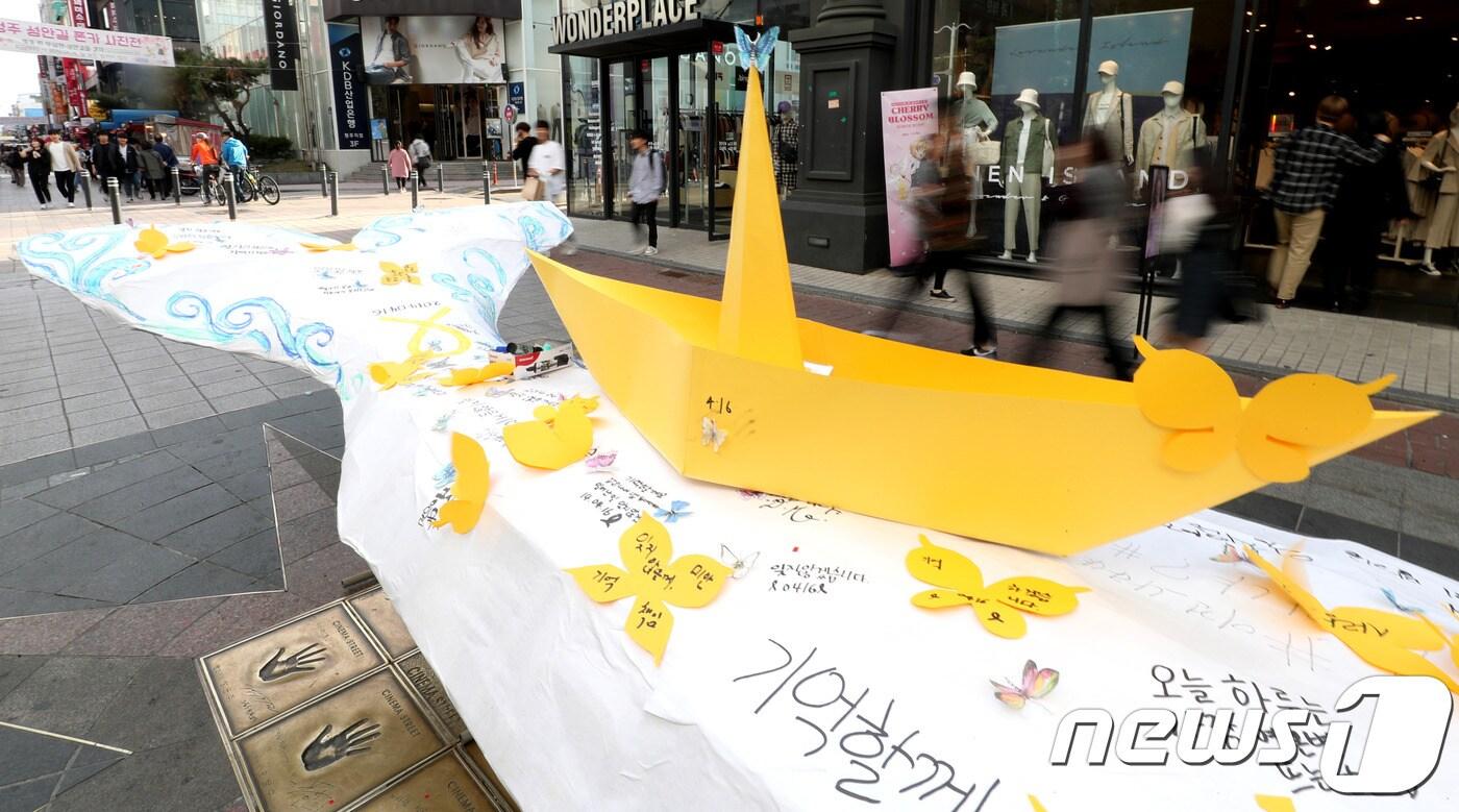  세월호 참사 5주기인 16일 충북 청주시 성안길에서 열린 ‘기억문화제’에서 시민들이 고래모형과 노란종이배에 추모 글귀를 작성하고 있다. 2019.4.16/뉴스1 ⓒ 뉴스1 김용빈 기자