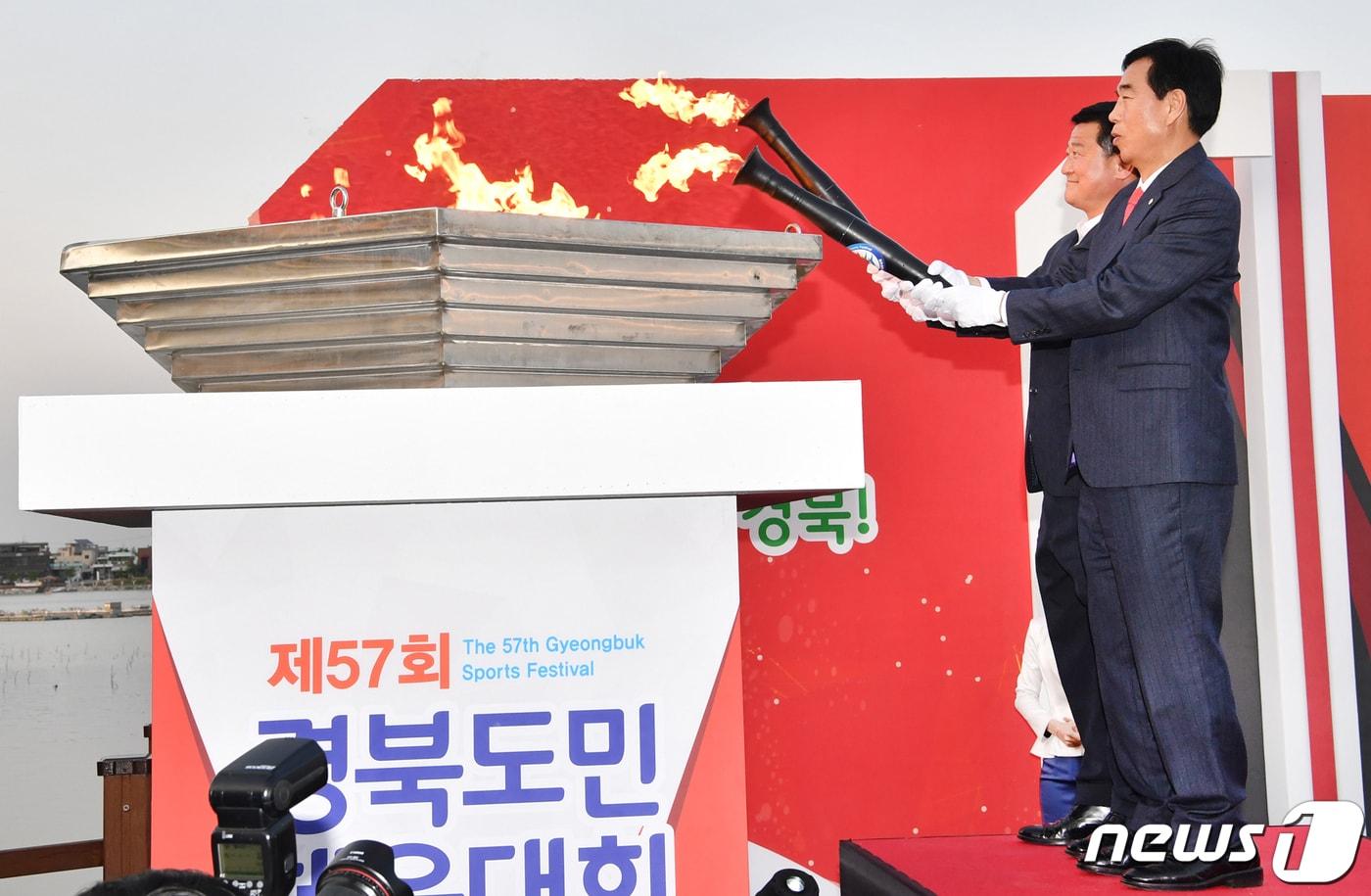본문 이미지 - 18일 오후 경산시 남매지 특설무대에서 열린 도민체전 성화 합화 안치식에서 최영조 경산시장(오른쪽)과 강수영 시의장이 성화를 합화하고 있다.경산 도민체전은 오는 19일부터 나흘간 경산시민운동장에서 펼쳐진다(경산시제공)2019.4.18/뉴스1 ⓒ News1 정우용 기자
