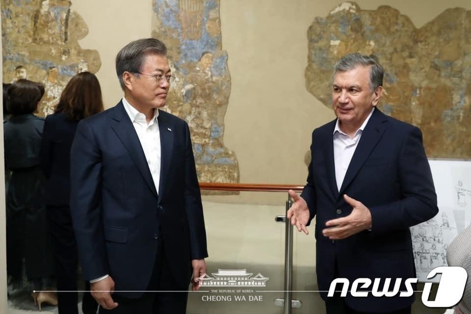 본문 이미지 - 문재인 대통령과 샤프카트 미르지요예프 우즈베키스탄 대통령이 20일 오후(현지시간) 우즈베키스탄 역사문화유적지 사마르칸트 아프라시아브 박물관에 있는 고구려 사신 벽화 앞에서 대화하고 있다.(청와대 페이스북) 2019.4.21/뉴스1
