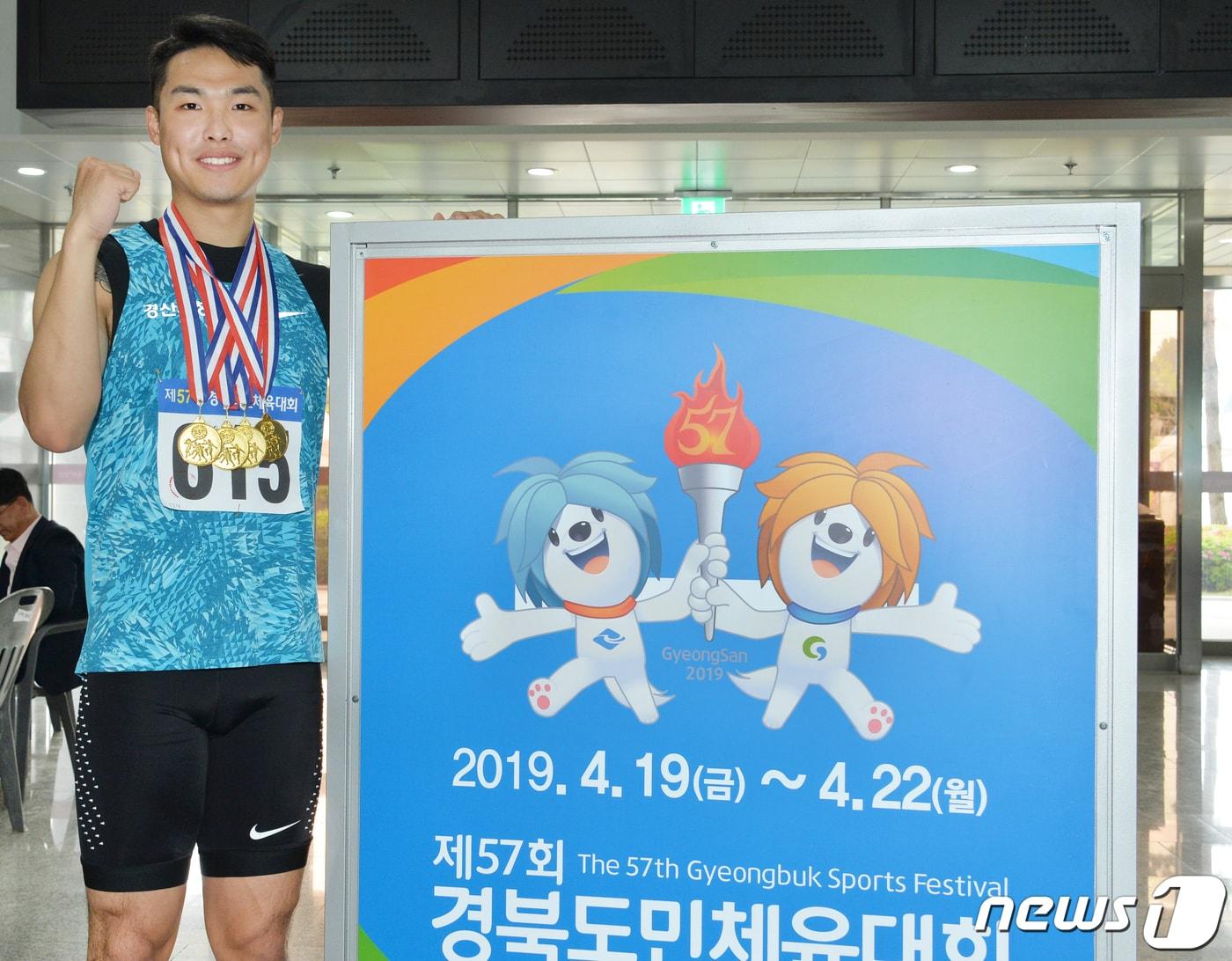 본문 이미지 - 제57회 경북도민체육대회 육상종목에서 4관왕을 차지한 경산시 이규형 선수가 4개의 금메달을 목에 걸고 도민체전 안내판옆에서 기념촬영을 하고 있다.(경산시제공)2019.4.21/뉴스1 ⓒ News1 