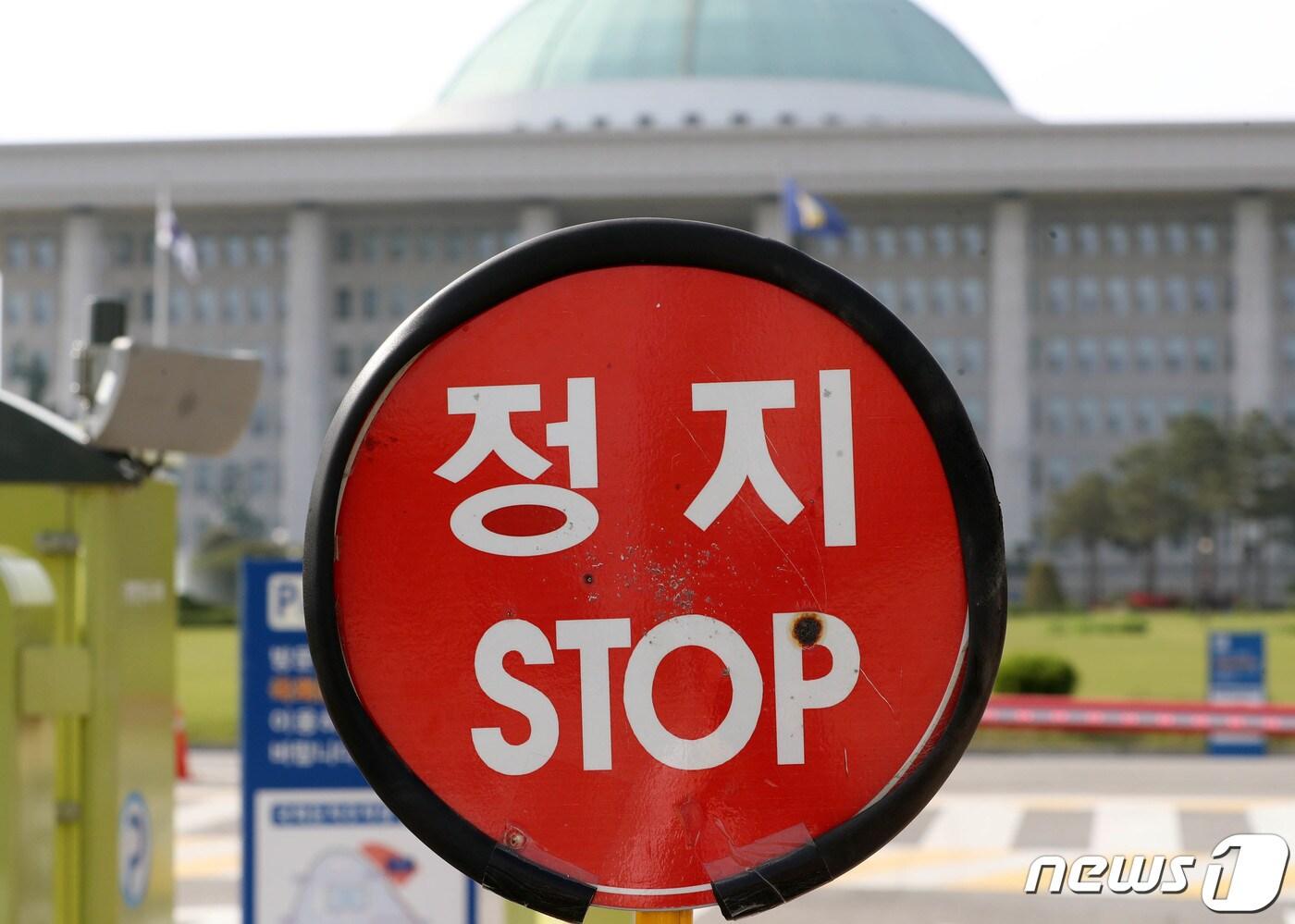 본문 이미지 - 30일 서울 여의도 국회 정문에서 경찰이 차량 통제용 정지 팻말을 세우고 있다. 2019.4.30/뉴스1 ⓒ News1 이종덕 기자