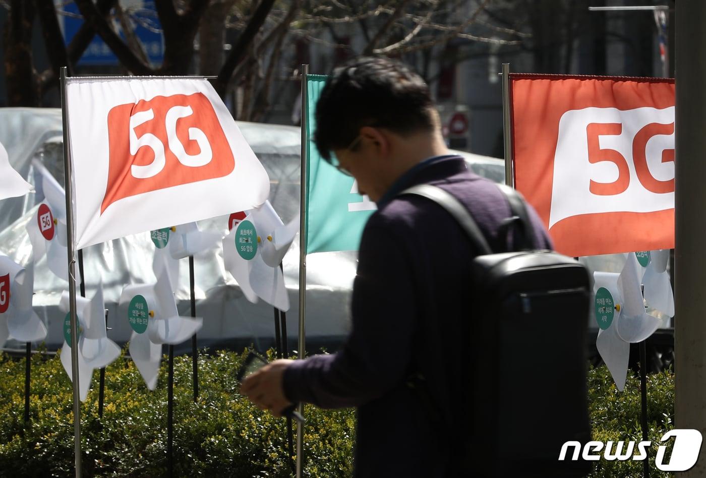 본문 이미지 - 서울 시내의 한 휴대폰 전시장 인근에 5G 상용화를 알리는 깃발이 바람에 날리고 있다. 2019.4.8/뉴스1 ⓒ News1 이승배 기자