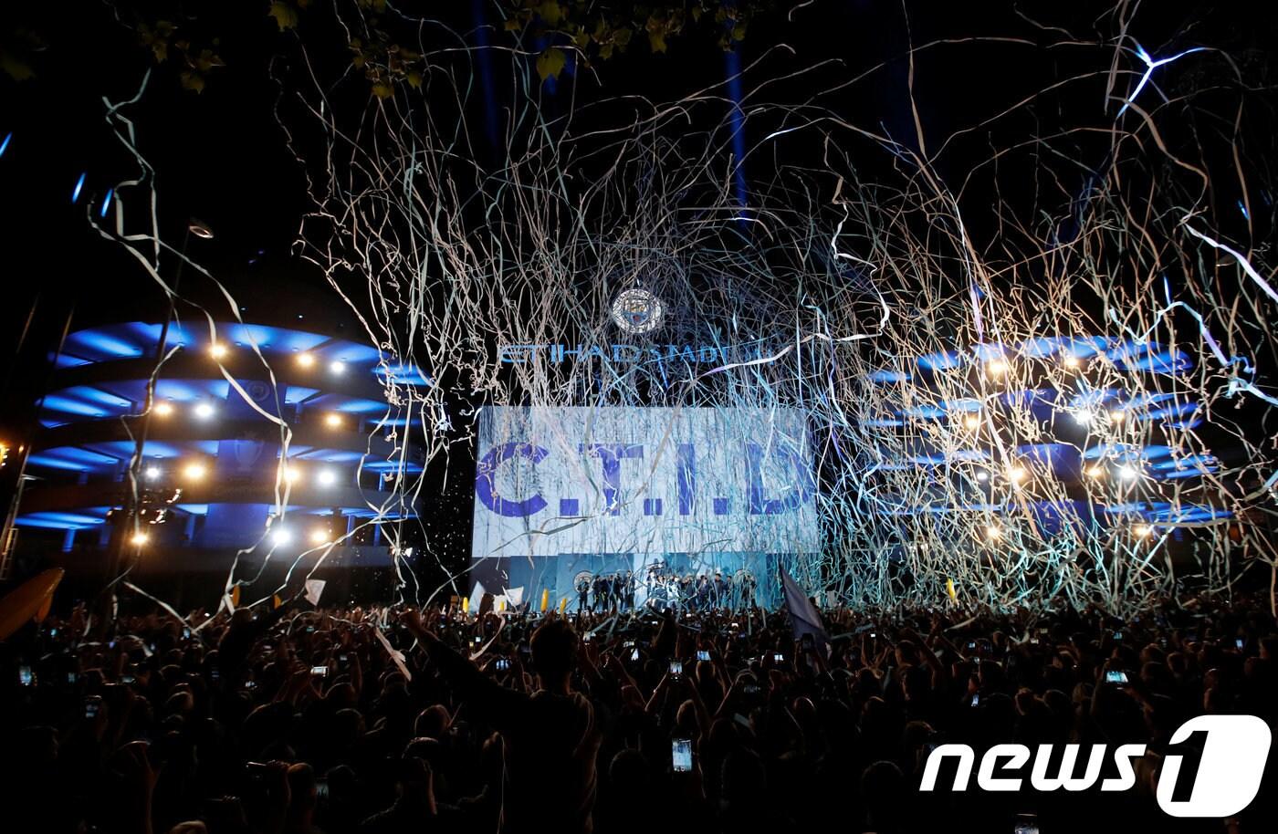 맨시티 선수와 팬들이 12일 (현지시간) 맨체스터의 에티하드 스타디움에서 프리미어리그(EPL) 우승 축하행사를 하고 있다. 맨시티는 이날 브라이튼을 꺾고 승점 98점으로 리버풀을 1점차로 뿌리치고 2년 연속 EPL 타이틀을 거머쥐었다. ⓒ 로이터=뉴스1 ⓒ News1 우동명 기자