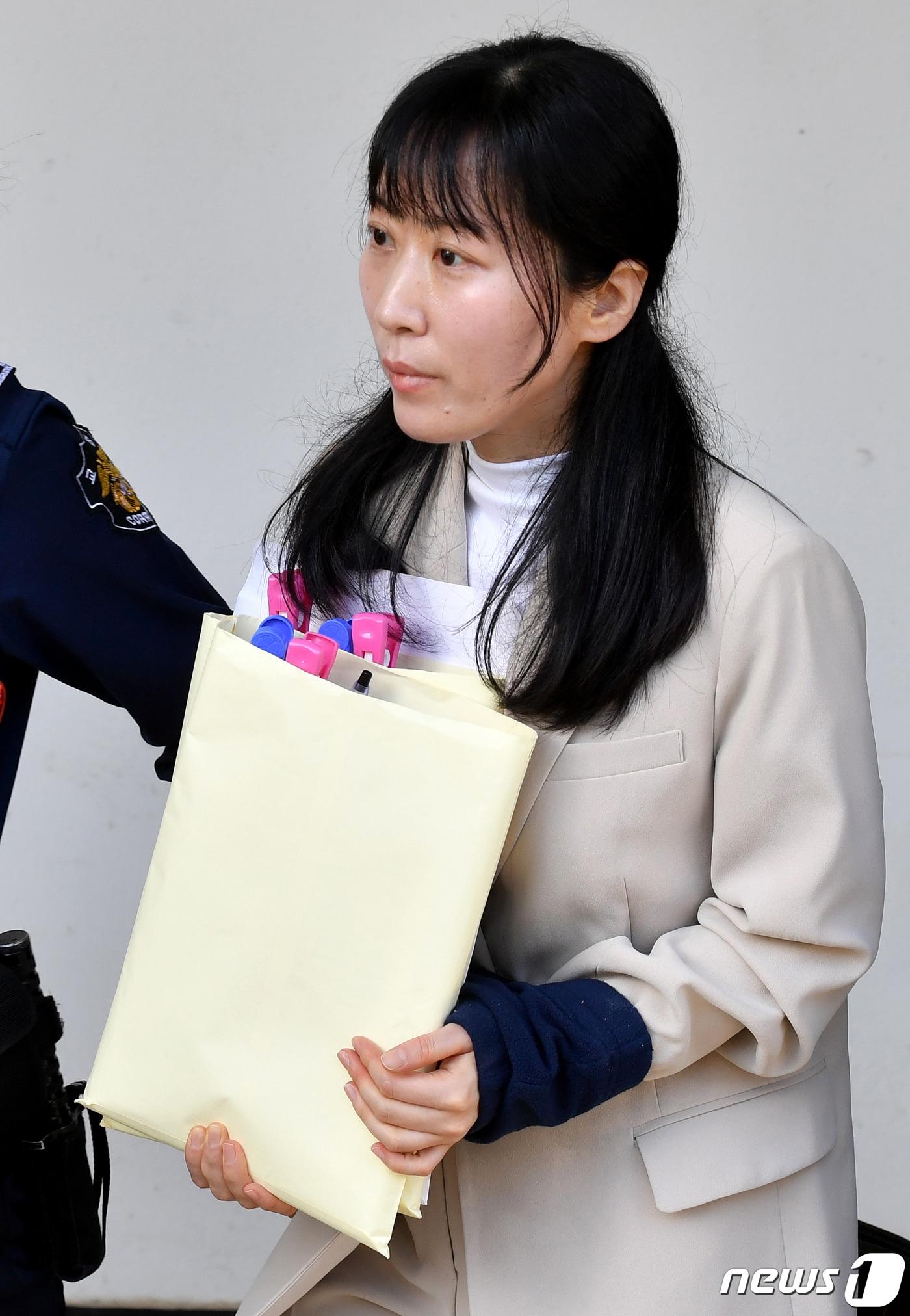 본문 이미지 - 친아버지를 살해한 혐의로 무기징역을 선고받고 복역 중인 김신혜씨(41)가 2019년 5월 20일 오후 전남 해남군 광주지방법원 해남지원에서 첫 재심 공판을 마친 뒤 호송되고 있다. 김씨는 이날 공판에서 "자신이 친아버지를 죽이지 않았다＂면서 ＂위조된 자료로 누명을 썼다＂고 주장했다.. 2019.5.20/뉴스1 ⓒ News1 한산 기자