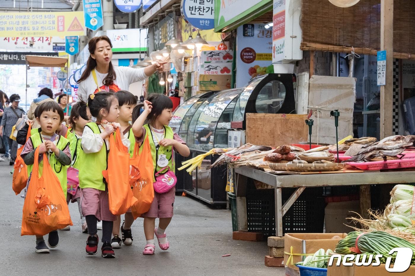 본문 이미지 - 23일 서울 광진구 자양시장에서 열린 '우리동네 시장 나들이' 행사에 참여한 어린이들이 장을 보고 있다. 시장상인회가 주최하는 이번 행사는 전통시장을 주민과 친근한 장소로 만들어 자주 찾을 수 있는 생활공간으로 바꾸기 위해 마련됐다. (광진구청 제공) 2019.5.23/뉴스1