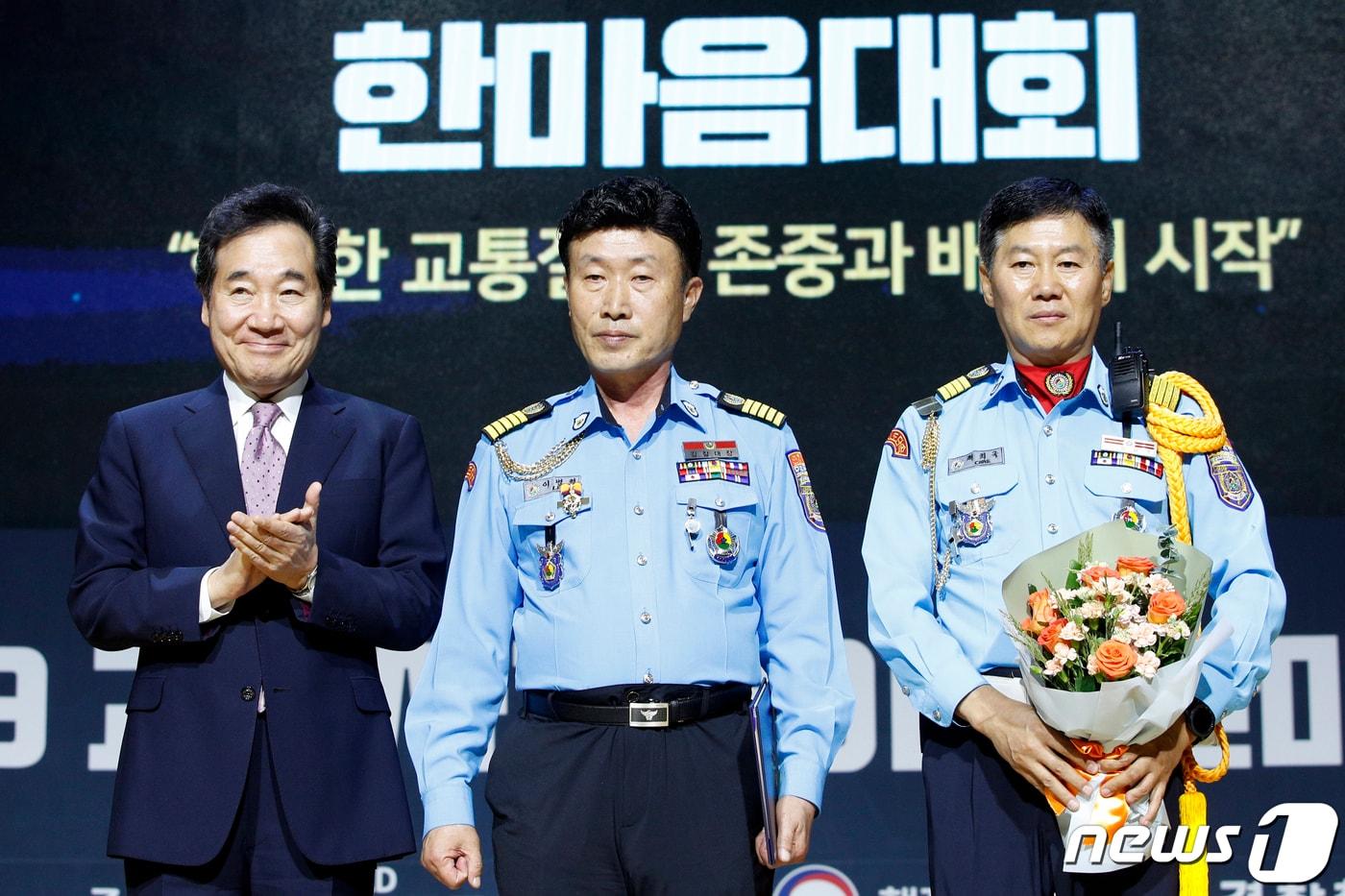 본문 이미지 - 이낙연 총리가 2019 교통사고 줄이기 한마음대회에서 대구북부 모범운전자회 이병희씨에게 교통사고 감소와 교통안전 확립을 위해 이바지한 공로로 대통령 표창을 수여한 뒤 기념촬영을 하고 있다. 안은나 기자