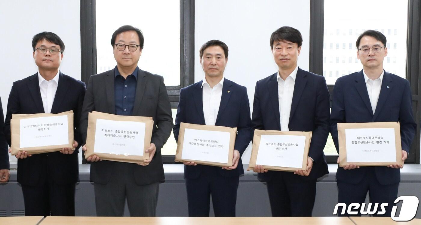 본문 이미지 - 지난해 5월, SK브로드밴드의 티브로드 인수합병을 위해 이상헌 SKT 정책개발실 상무(왼쪽 두번째) 등 관계자들이 SK브로드밴드와 티브로드 및 티브로드 계열법인의 M&A 관련 변경허가‧인가 등 신청서를 제출하는 모습. 2019.5.9/뉴스1 ⓒ News1 허경 기자