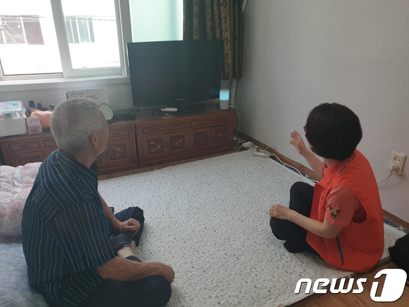 본문 이미지 - 인공지능 돌봄서비스를 받고 있는 김정식씨(76세, 가명, 왼쪽)와 박주은 케어매니저가 인공지능 스피커를 사용해보고 있다. ⓒ 뉴스1 강은성 기자 