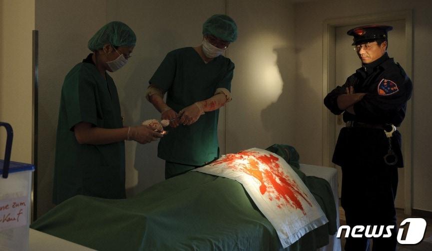 본문 이미지 - 지난 2012년 독일에서 파룬궁 수련자들이 장기 적출 현장을 고발하는 연극 공연을 펼치고 있다.ⓒ AFP=뉴스1