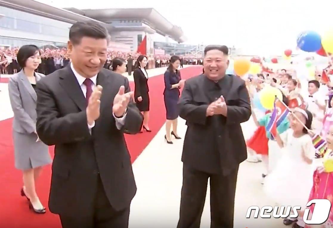 본문 이미지 - 지난 2019년 6월 20일 시진핑(習近平) 중국 국가주석이 평양 순안공항(평양국제비행장)에서 도착해 영접나온 김정은 국무위원장과 함께 환호하는 아이들에게 박수치고 있다. (CCTV 화면 캡쳐)2019.6.20 ⓒ 뉴스1