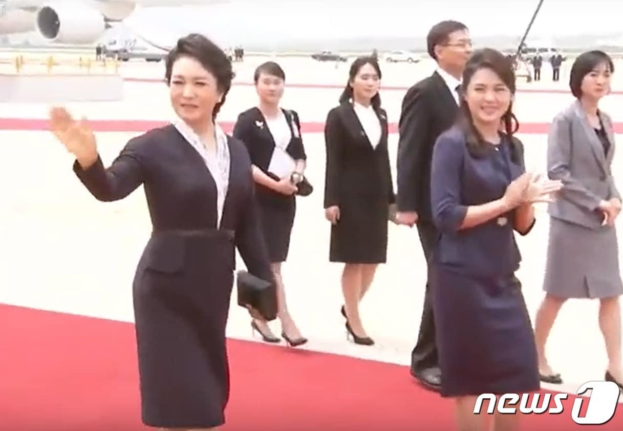본문 이미지 - 2019년 6월 20일 시진핑(習近平) 중국 국가주석과 함께 1박2일간의 북한 국빈방문을 위해 평양 순안공항(평양국제비행장)에 도착한 펑리위안 여사가 환영 인파를 향해 손인사를 하고 있다. 오른쪽 두번째는 김정은 국무위원장의 부인 리설주 여사. (CCTV화면 캡쳐)2019.6.20 ⓒ 뉴스1