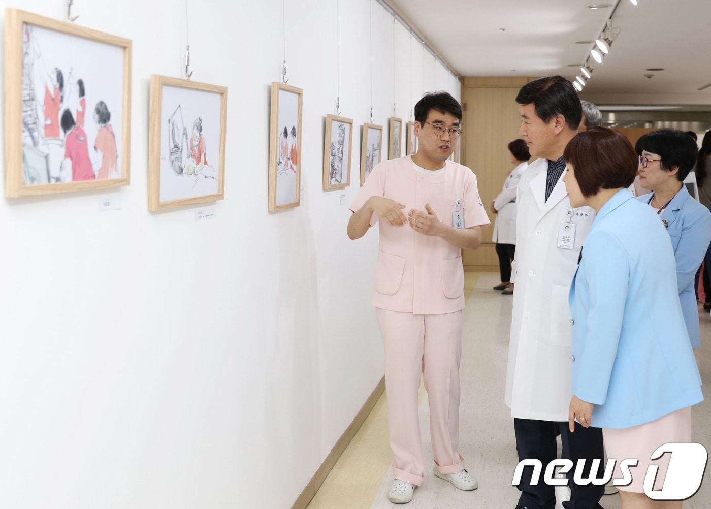 본문 이미지 - 길병원 오영준 간호사가 김양우 원장에게 웹툰을 설명하고 있다.(길병원제공)ⓒ 뉴스1