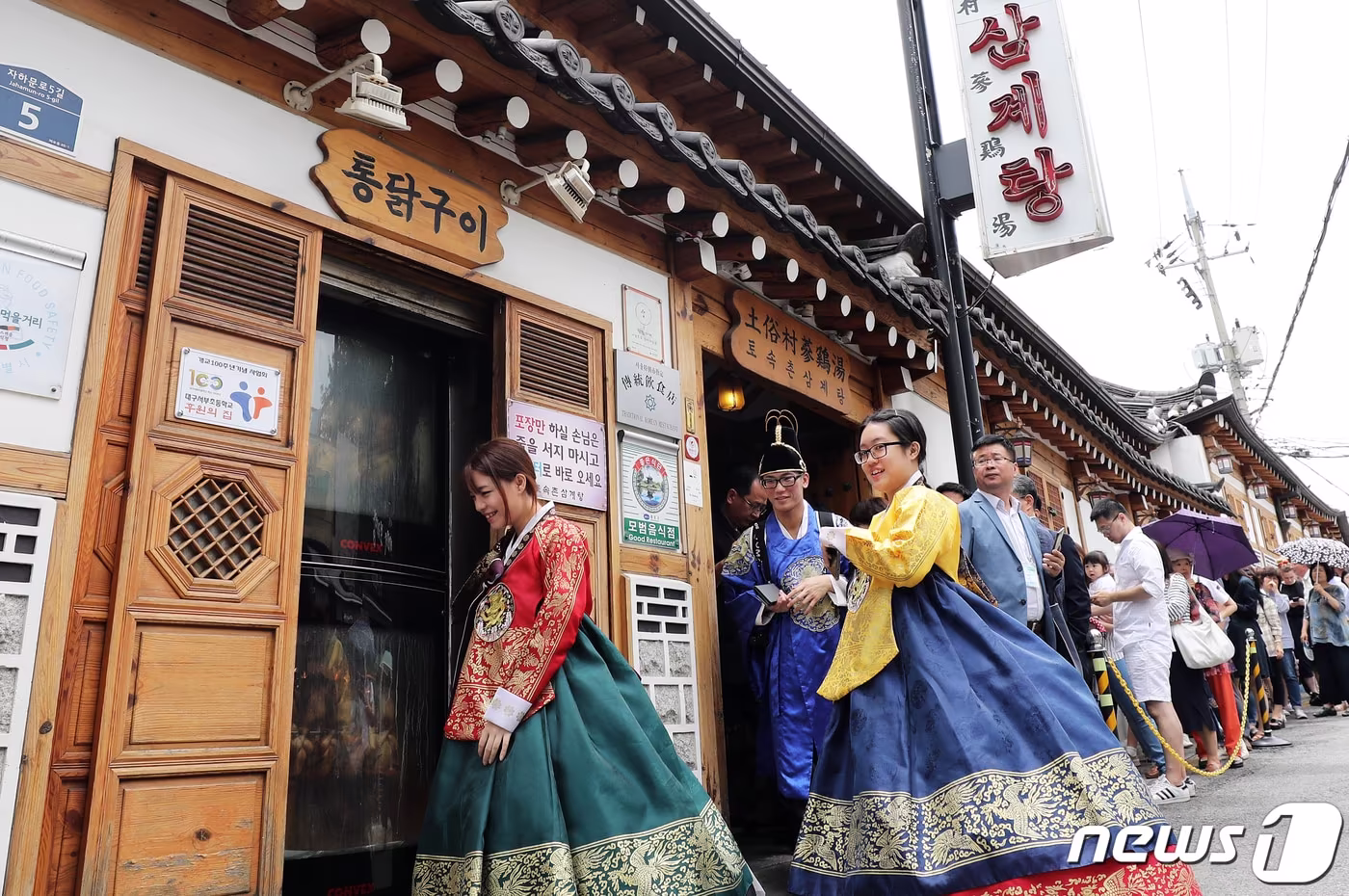 본문 이미지 - 초복을 하루 앞둔 11일 한복을 곱게 차려 입은 외국인 관광객들이 서울 종로구의 한 삼계탕집에서 보양식을 먹은 뒤 자리를 뜨고 있다. 2019.7.11/뉴스1 ⓒ News1 오대일 기자