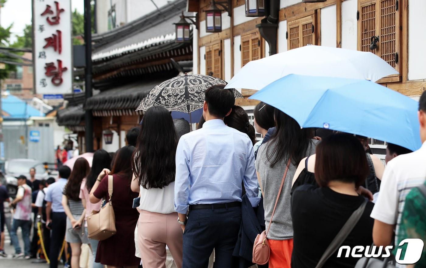 본문 이미지 - 초복을 하루 앞둔 11일 서울 종로구의 한 삼계탕 전문점이 보양식을 먹으러 온 시민과 외국인 관광객들로 문전성시를 이루고 있다. 2019.7.11/뉴스1 ⓒ News1 오대일 기자