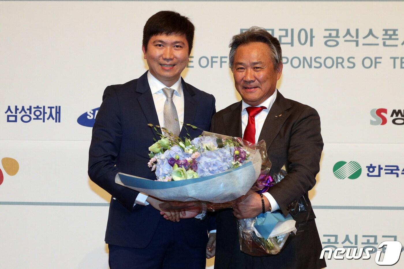 본문 이미지 - 이기흥 대한체육회 회장이 지난달 11일 오후 서울 중구 롯데호텔에서 열린 '대한체육회 창립 99주년 기념식·이기흥 회장 국제올림픽위원회(IOC)위원 선출 축하행사'에서 유승민 대한탁구협회 회장 겸 IOC 선수위원에게 꽃다발을 받고 있다. 2019.7.11/뉴스1 ⓒ News1 황기선 기자