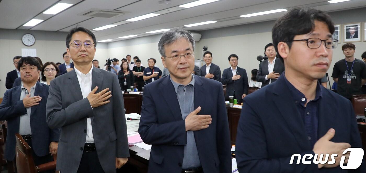 최저임금위원회 공익위원들이 11일 정부세종청사 고용노동부 전원회의장에서 열린 최저임금위원회 12차 전원회의에서 국민의례를 하고 있다.  2019.7.11/뉴스1