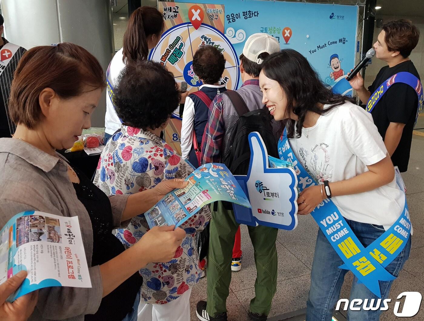 본문 이미지 - 15일 서울 청량리역에서 열린 ‘2019 국토정중앙 양구 배꼽축제 홍보 캠페인’에서 양구군 직원들이 시민들을 대상으로 홍보활동을 하고 있다. 이번 양구 배꼽축제는 오는 8월2~4일 양구 레포츠공원 일대에서 열린다. (양구군 제공) 2019.7.15/뉴스1 ⓒ News1 하중천 기자