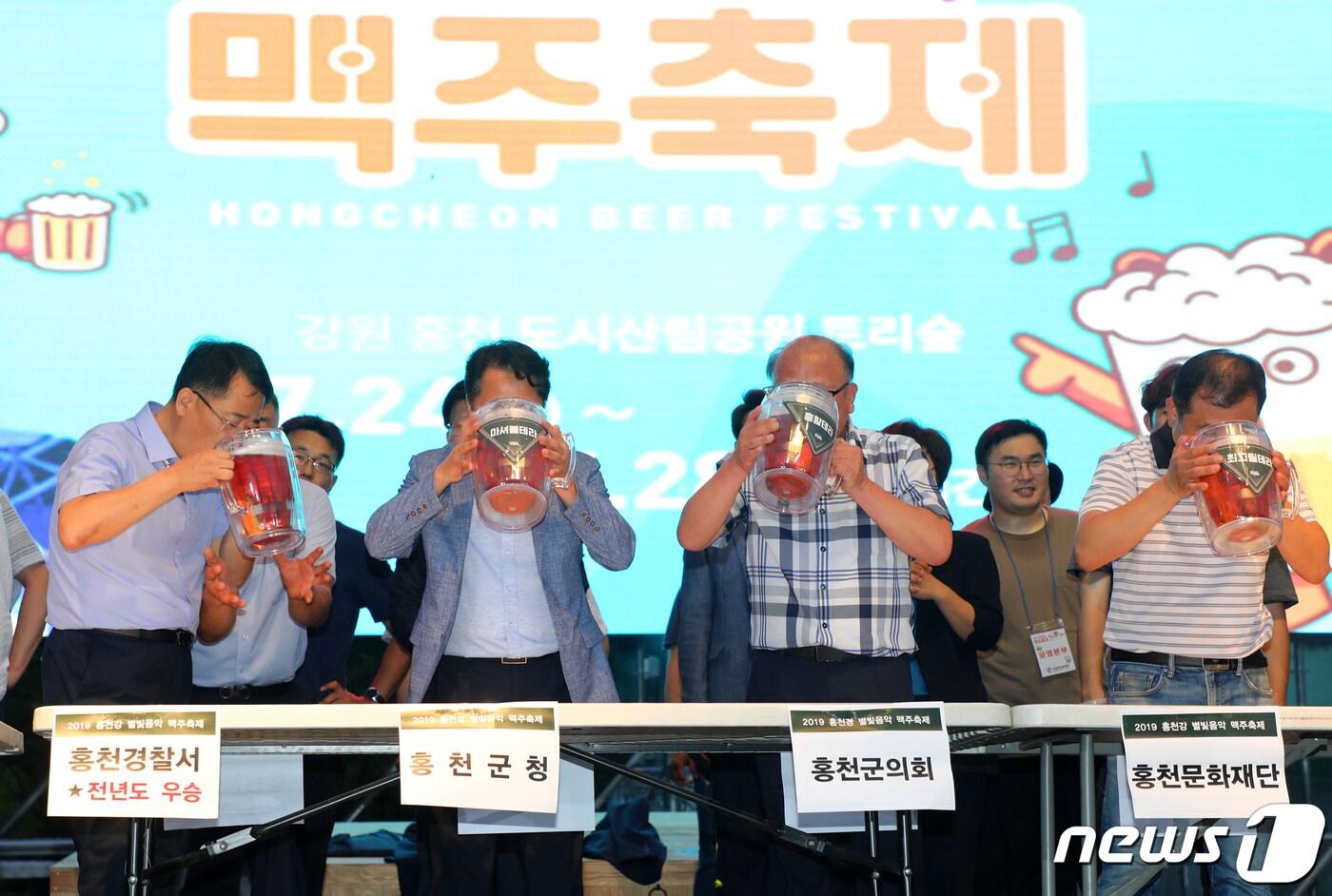 본문 이미지 - 24일 강원 홍천군 토리숲 일대에서 개막한 홍천강 별빛음악 맥주축제에서 맥주 빨리 마시기 대회가 열리고 있다. 대회에는 군청, 의회, 경찰서, 소방서 등 지역 기관이 참여했다. 2019.7.24/뉴스1 ⓒ News1 하중천 기자