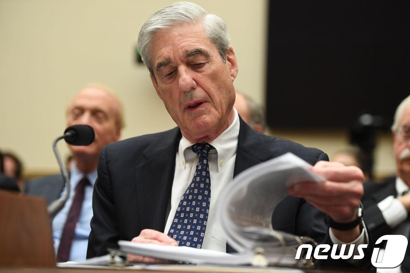 본문 이미지 - 도널드 트럼프 미국 대통령의 '러시아 스캔들' 의혹을 수사했던 로버트 뮬러 전 특별검사가 24일 (현지시간) 워싱턴 하원 법사위원회 청문회에 출석해 자료를 살펴보고 있다. ⓒ AFP=뉴스1