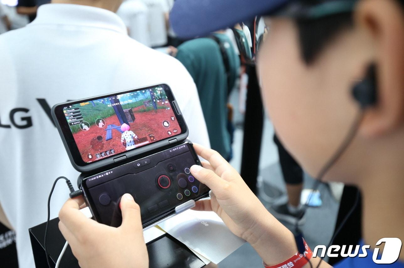 본문 이미지 - 지난 7월20일 롯데월드 아이스링크에서 열린 LG V50 ThinQ 게임 페스티벌에 방문한 관람객들이 LG 듀얼 스크린으로 게임을 즐기는 모습. (LG전자 제공) 2019.7.31/뉴스1