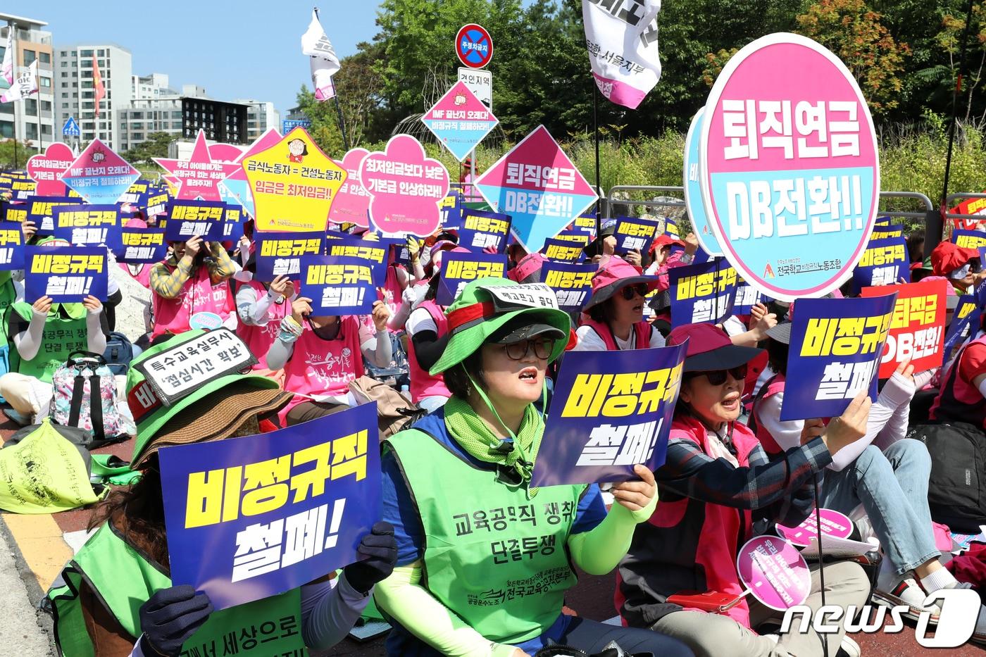 본문 이미지 - 민주노총 전국학교비정규직노동조합 조합원들이 4일 오전 서울교육청 앞에서 열린 '서울학교비정규직연대회의 총파업 대회'에서 손팻말을 들고 구호를 외치고 있다. 이날 조합원들은 비정규직 차별 철폐, 공공부문 정규직화, 처우개선 등을 촉구했다. 2019.7.4/뉴스1 ⓒ News1 황기선 기자