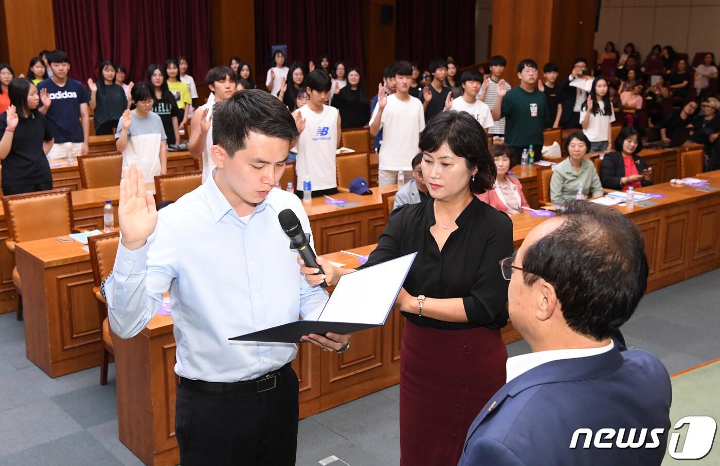 본문 이미지 - 12일 오후 부산시청 12층 국제회의장에서 열린 '일본군 위안부 피해자 기림주간'에서 평화의 소녀상 지킴이단 대표가 오거돈 부산시장에게 위촉장을 수여 받고 선서를 하고 있다. 평화의 소녀상 지킴이단은 부산지역 중,고,대학생 50여 명으로 구성된 자원봉사단체이다. 2019.8.12/뉴스1 ⓒ News1 여주연 기자