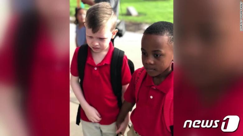 본문 이미지 - 자폐증을 앓고 있는 같은 반 친구의 손을 잡아주고 있는 크리스찬 무어(오른쪽) ⓒ 뉴스1