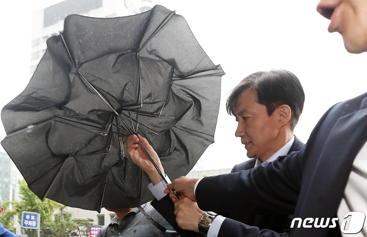 본문 이미지 - 조국 법무부 장관 후보자가 국회 인사청문회를 나흘 앞둔 29일 오전 서울 종로구에 마련된 청문회 준비 사무실로 출근하며 우산을 접고 있다. 2019.8.29/뉴스1 ⓒ News1 오대일 기자