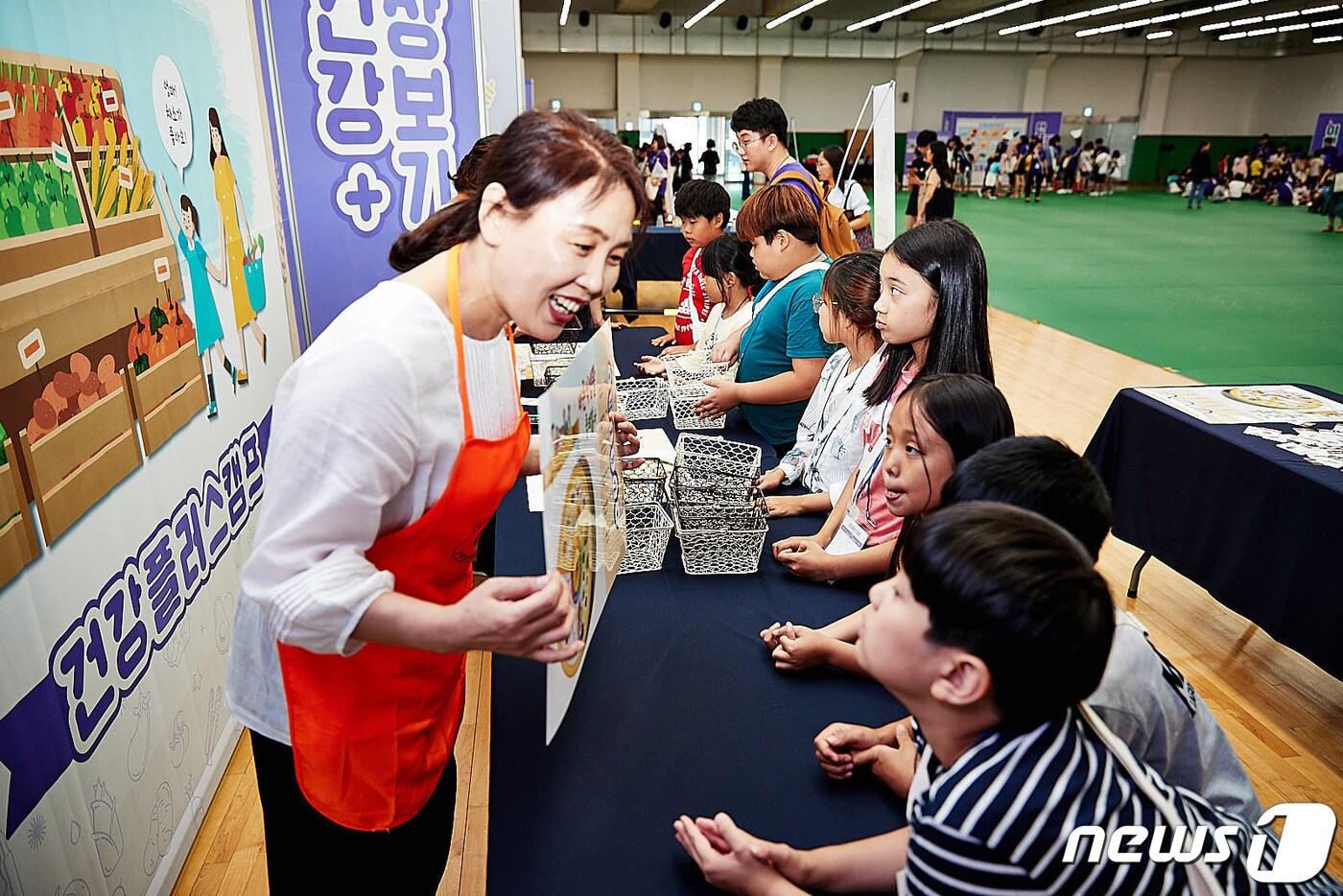 본문 이미지 - SK하이닉스 ‘건강플러스캠프’에 참여한 아동들이 장보기 체험활동을 하며 건강한 식재료에 대한 설명을 듣고 있다.( SK하이닉스 제공 )ⓒ News1 김평석 기자