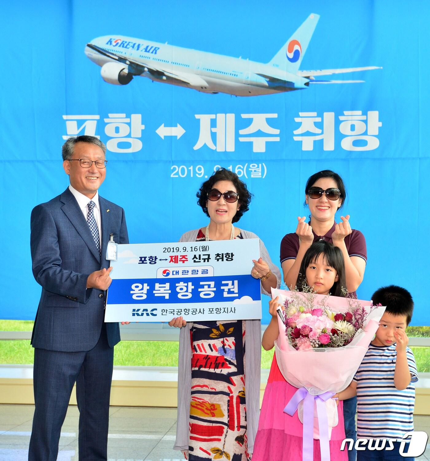 본문 이미지 - 16일 오후 경북 포항시 남구 포항공항에서 열린 포항~제주 항공편 취항 기념식에서 이재철 한국공항공사 포항지사장이 첫 고객에게 국내선 왕복 항공권과 꽃다발을 선물하고 있다. 이날 취항한 포항~제주 항공편은 하루 1차례 왕복 운항한다. 2019.9.16/뉴스1 ⓒ News1 최창호 기자