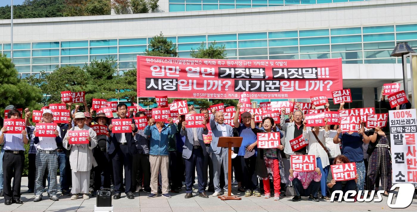본문 이미지 - 지난 19일 오후 강원도 원주시청앞 광장에서 열린 열병합발전소 건립 반대 단체 기자회견에서 참석자들이 '원주시장은 열병합발전소 건립하지 않을 것이라 했던 공약을 지키라'며 구호를 외치고 있다.2019.9.19/뉴스1 ⓒ News1 장시원 인턴기자