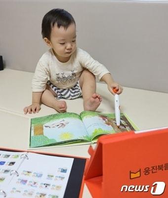 본문 이미지 - 영유아가 웅진 베베톡으로 그림책을 듣고 있다(웅진씽크빅 제공)ⓒ 뉴스1