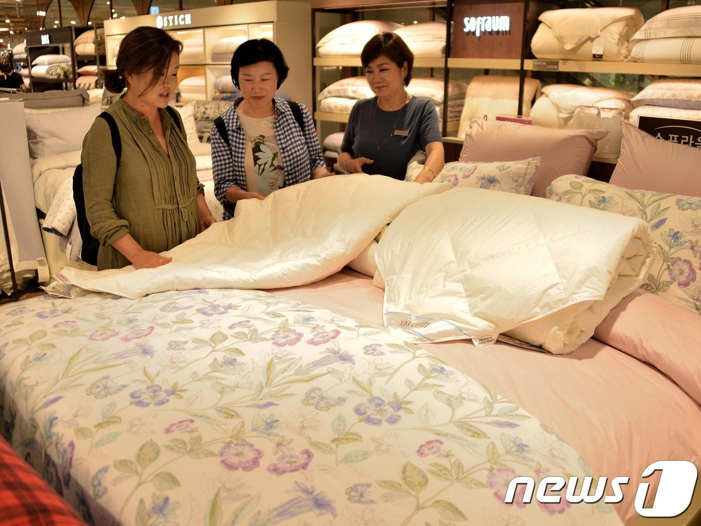 본문 이미지 - 부산지역 롯데백화점 침구매장을 찾은 한 고객이 구스이불을 살펴보고 있다.(롯데쇼핑 제공)ⓒ 뉴스1