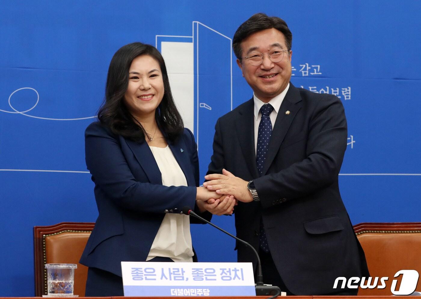 윤호중 더불어민주당 사무총장이 16일 오전 서울 여의도 국회에서 열린 인재영입 발표 행사에서 글로벌 이코노미스트 최지은 박사에게 당배지를 꽃다발을 전달하고 있다. 2020.1.16/뉴스1 ⓒ News1 박세연 기자