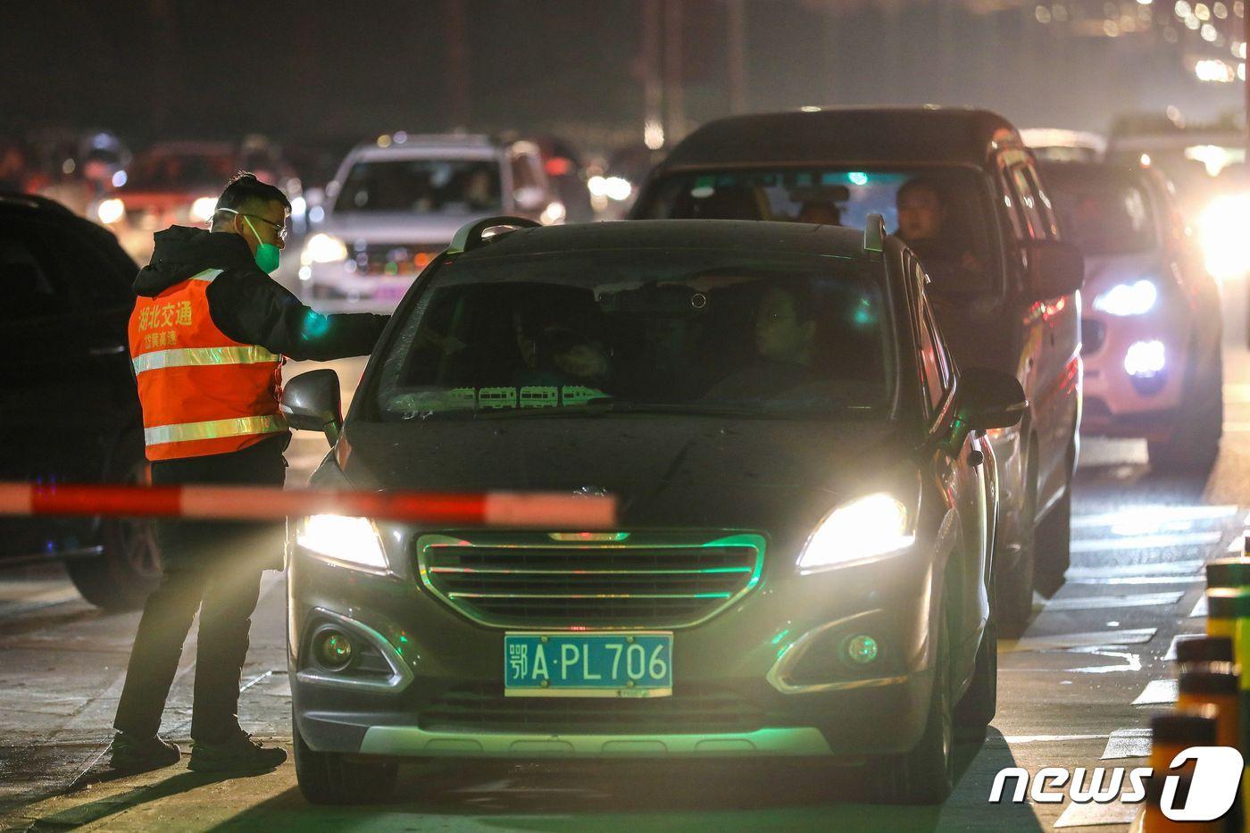 중국 후베이성 우한의 고속도로 출구에서 신종 코로나바이러스인 우한 폐렴의 확산을 막기위해 직원들이 승객들의 체온을 측정하고 있다. ⓒ AFP=뉴스1 ⓒ News1 우동명 기자