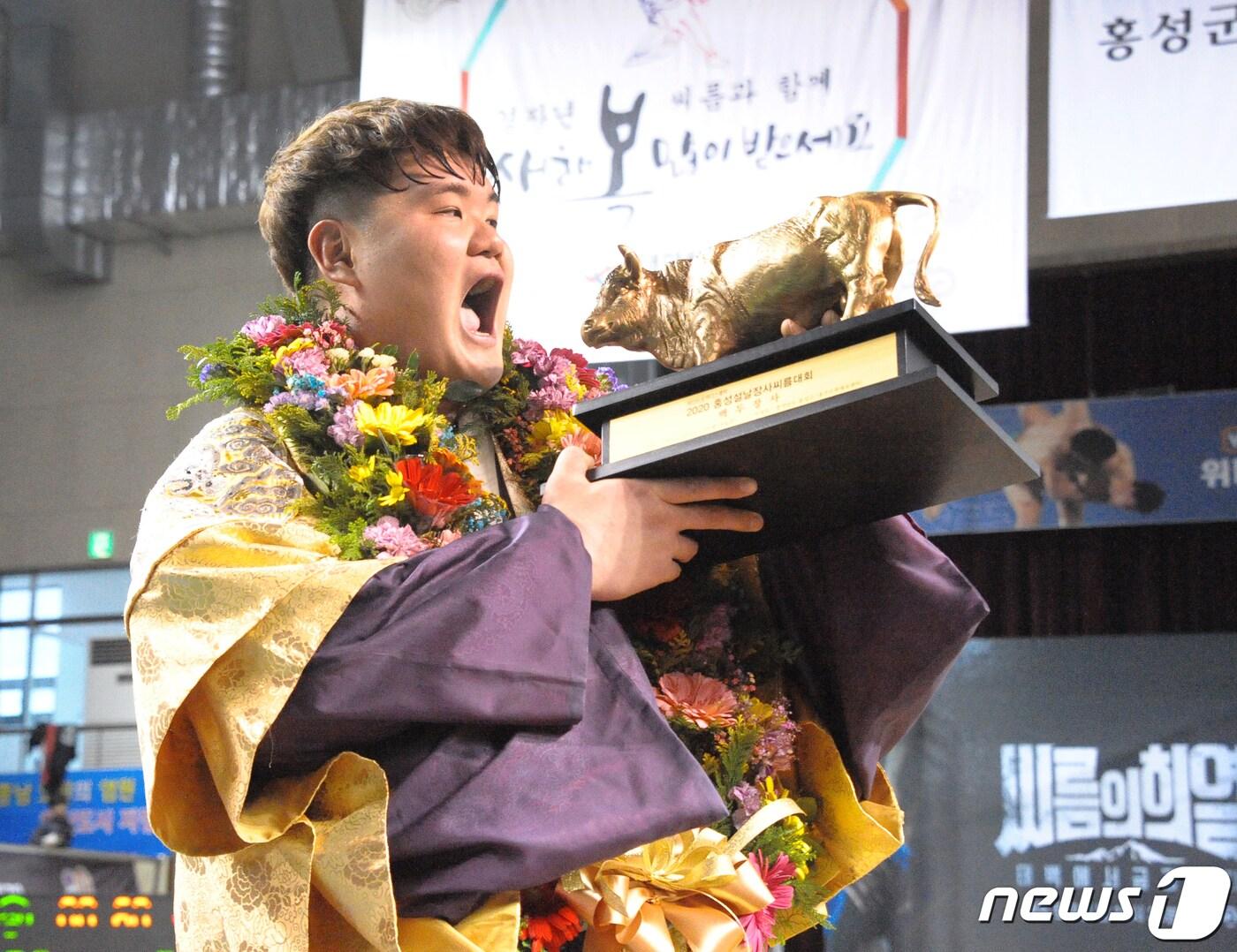 본문 이미지 - 26일 충남 홍성군 홍주문화체육센터에서 열린 위더스제약 2020 홍성설날장사씨름대회에서 백두장사(140kg이하)에 등극한 장성우(영암군민속씨름단)가 황소트로피를 들고 환호하고 있다.(대한씨름협회 제공) 2020.1.26/뉴스1