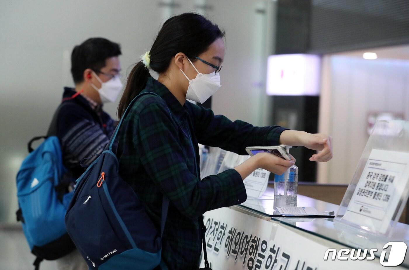 지난달 27일 오후 인천국제공항 제1여객터미널에서 마스크를 쓴 승객들이 손소독제를 이용하고 있다. 2020.1.27/뉴스1 ⓒ News1 이동해 기자