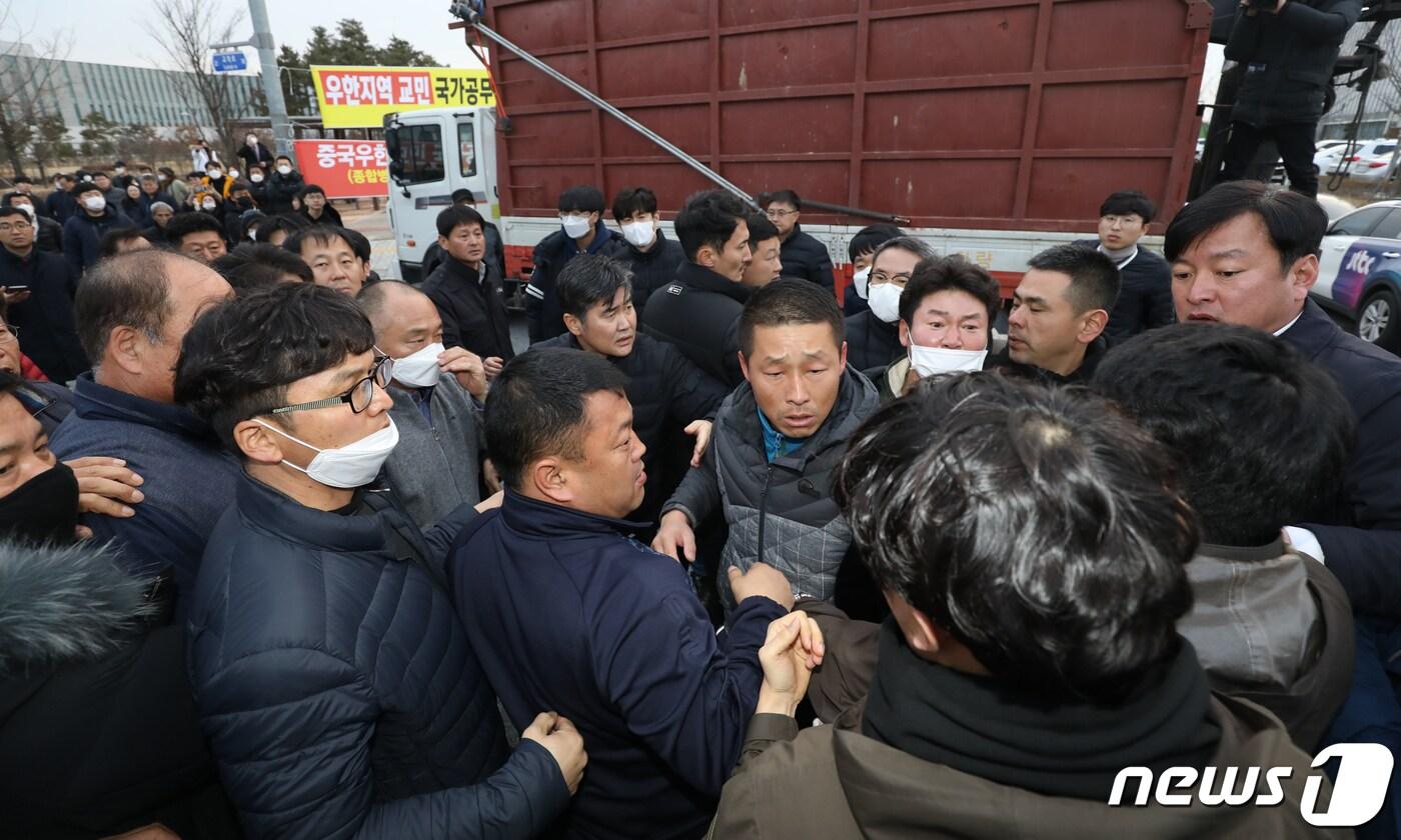 본문 이미지 - 29일 오후 우한 교민들이 수용될 충북 진천군 국가공무원 인재개발원 앞에서 주민들과 경찰이 입구 봉쇄 과정에서 몸싸움을 벌이고 있다. 정부는 이날 충남 아산시에 위치한 '경찰인재개발원'과 충북 진천군의 국가공무원인재개발원 2곳에 우한에서 귀국을 희망하는 한국인 720명을 분산 수용하겠다고 발표했다. 2020.1.29/뉴스1 ⓒ News1 김용빈 기자
