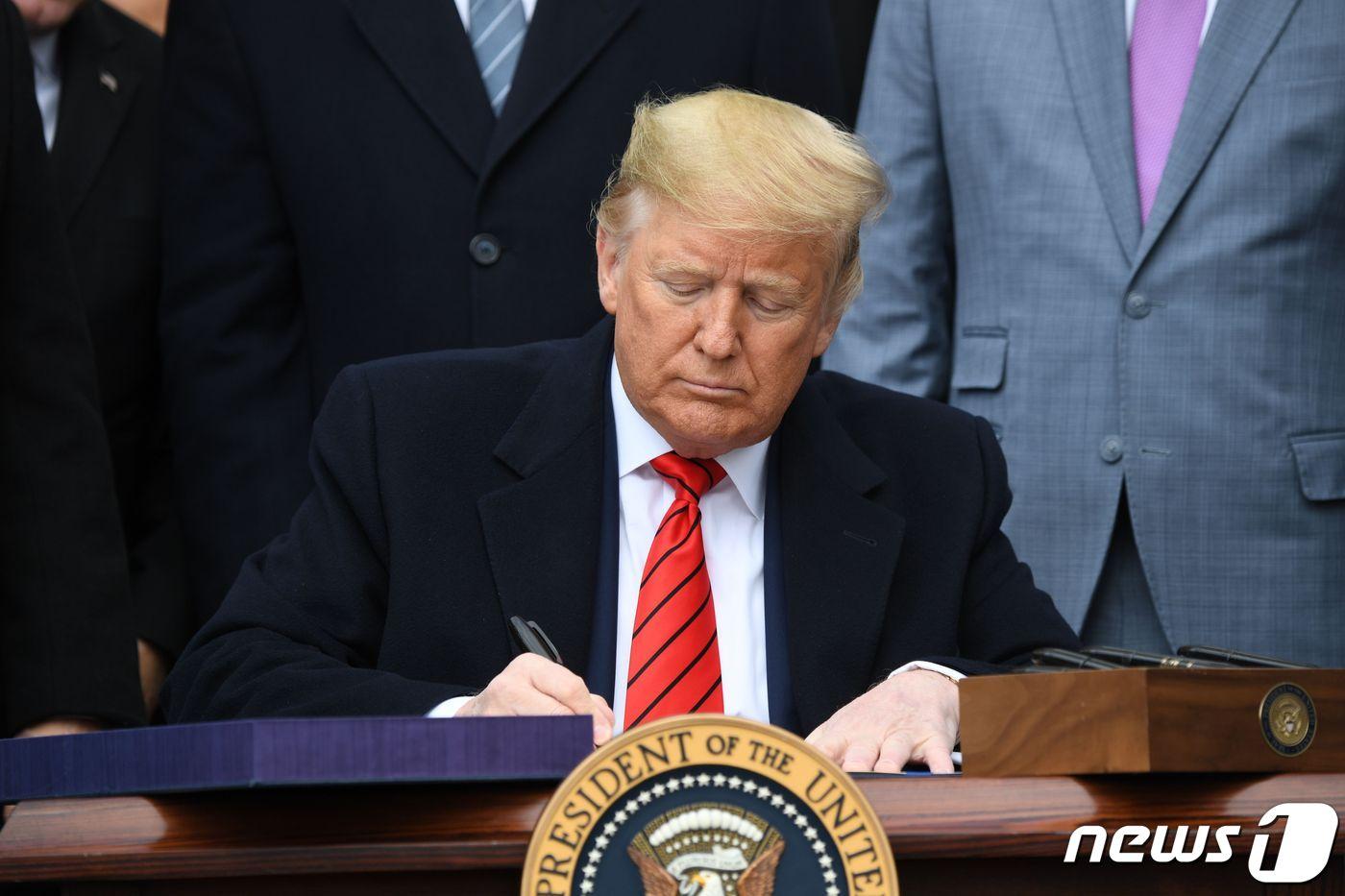 본문 이미지 - 도널드 트럼프 미국 대통령이 29일(현지시간) 워싱턴 백악관에서 기존 북미자유무역협정(NAFTA)을 대체하는 새 북미무역협정인 '미국·멕시코·캐나다 협정'(USMCA)에 서명을 하고 있다. ⓒ AFP=뉴스1 ⓒ News1 우동명 기자