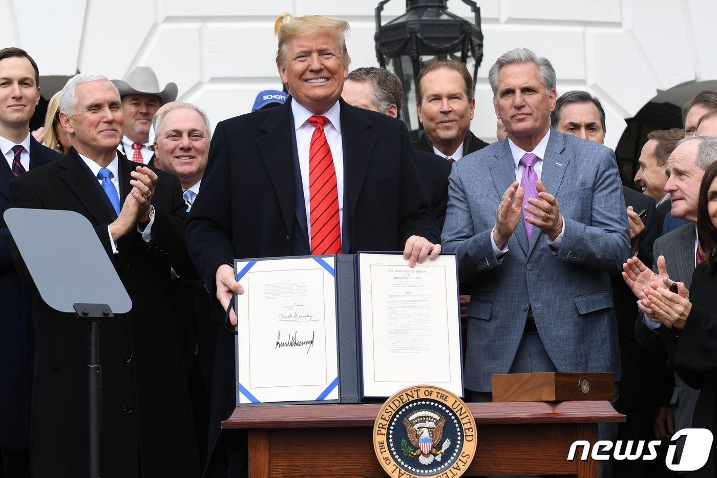 본문 이미지 - 도널드 트럼프 미국 대통령이 2020년 1월29일(현지시간) 워싱턴 백악관에서 기존 북미자유무역협정(NAFTA)을 대체하는 새 북미무역협정인 미국·멕시코·캐나다 협정(USMCA) 서명문서를 들고 있다. ⓒ AFP=뉴스1