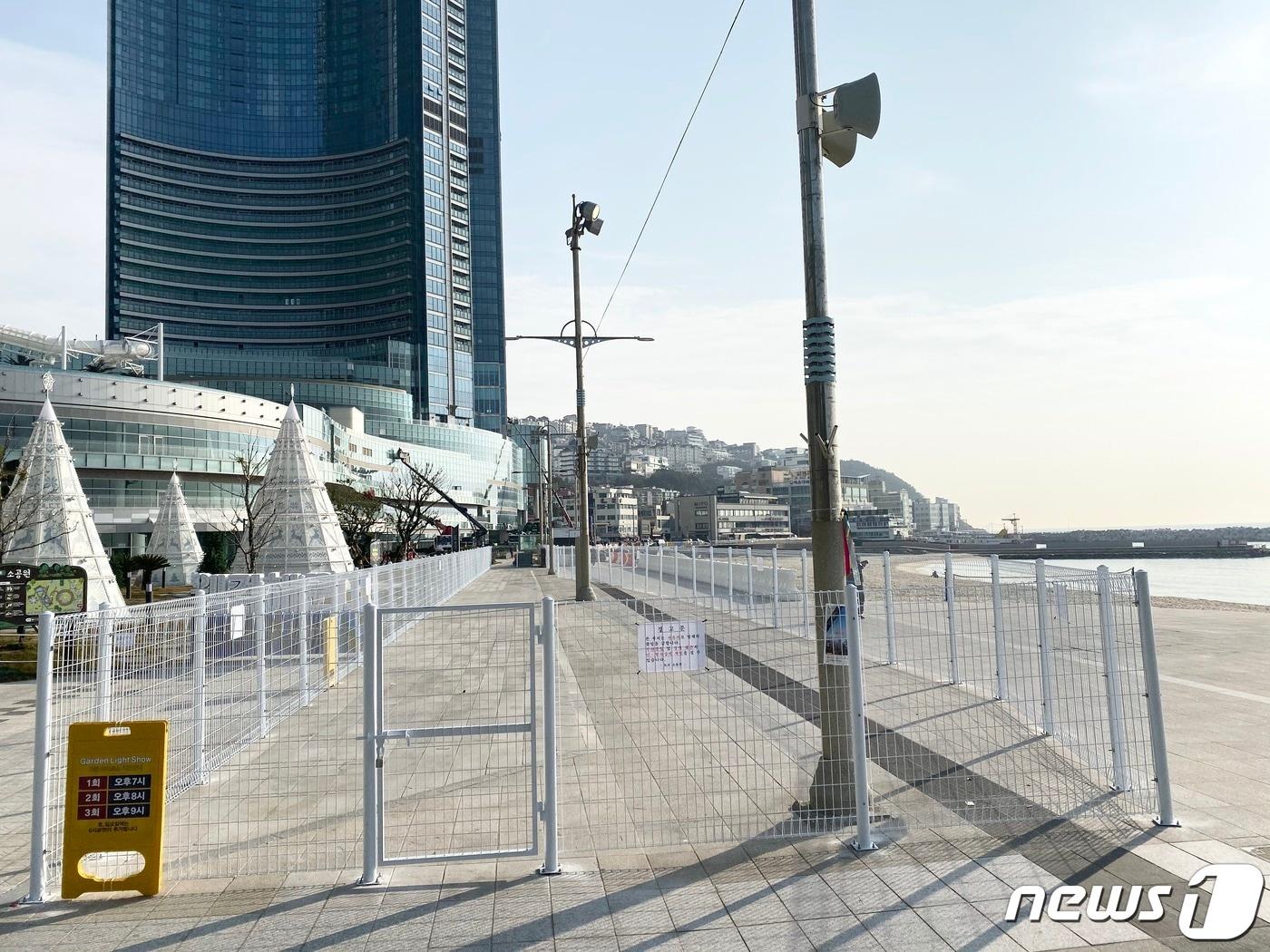 본문 이미지 - 부산 해운대 초고층 아파트인 엘시티 앞 보행로에 설치 됐던 펜스가 알박기 논란 끝에 철거될 예정이다. 부지 소유주인 우신종합건설측과 엘시티가 부지매각에 합의하면서다. 사진은 엘시티 앞에 설치된 펜스.ⓒ 뉴스1 박세진 기자