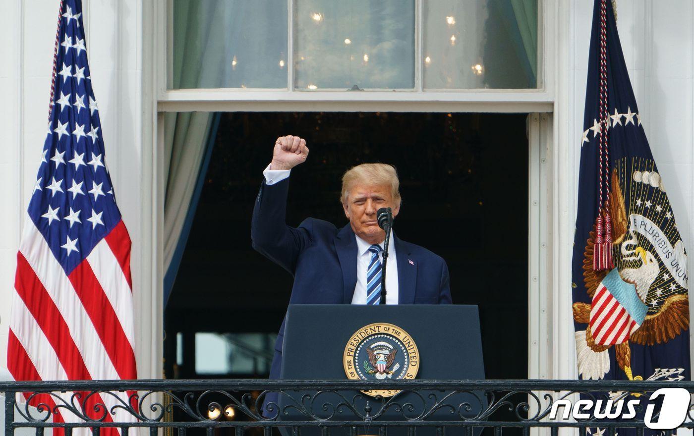 도널드 트럼프 미국 대통령이 10일(현지시간) 오후 백악관 발코니에 나와 지지자들을 향해 주먹 쥔 손을 들어보이고 있다. ⓒ AFP=뉴스1