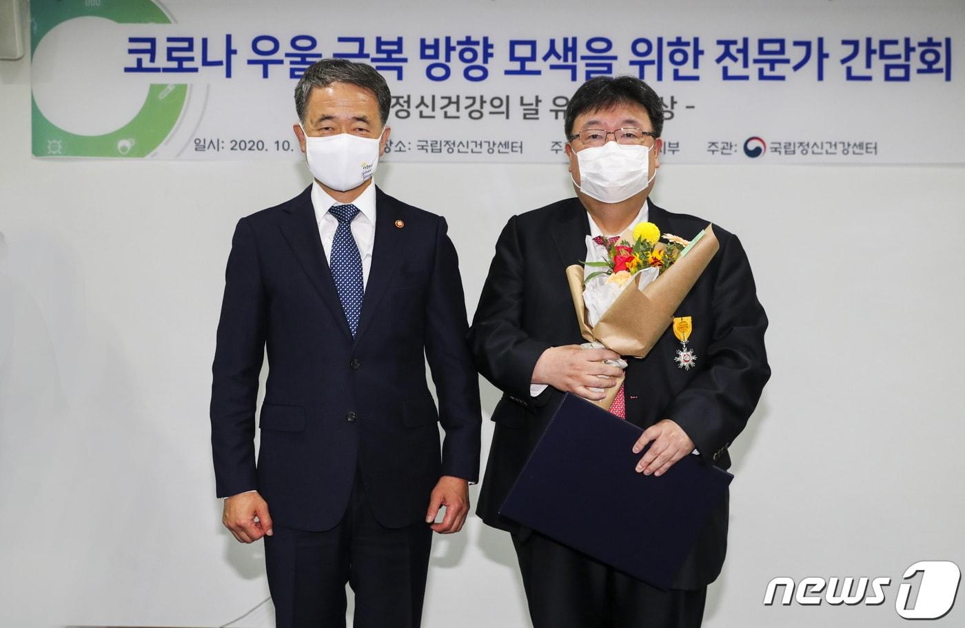 본문 이미지 - 박능후 보건복지부 장관이 가톨릭관동대국제성모병원 기선완 교수에게 국민포장을 수여한 후 기념사진을 촬영하고 있다.(국제성모병원 제공) ⓒ 뉴스1